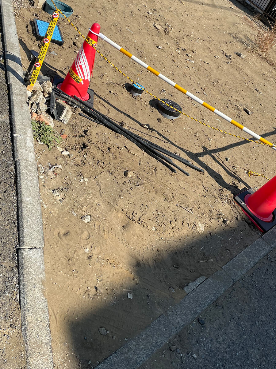 角地の隅切り予定ラインに合わせて設置した三角コーンとバー